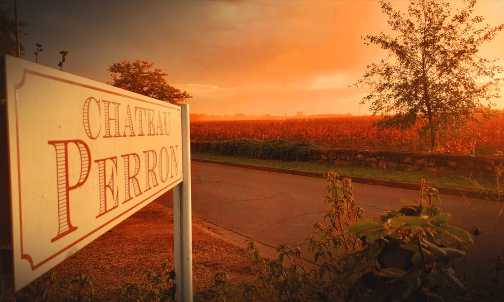 Panneau du Château Perron et ses vignes pendant un coucher de soleil.